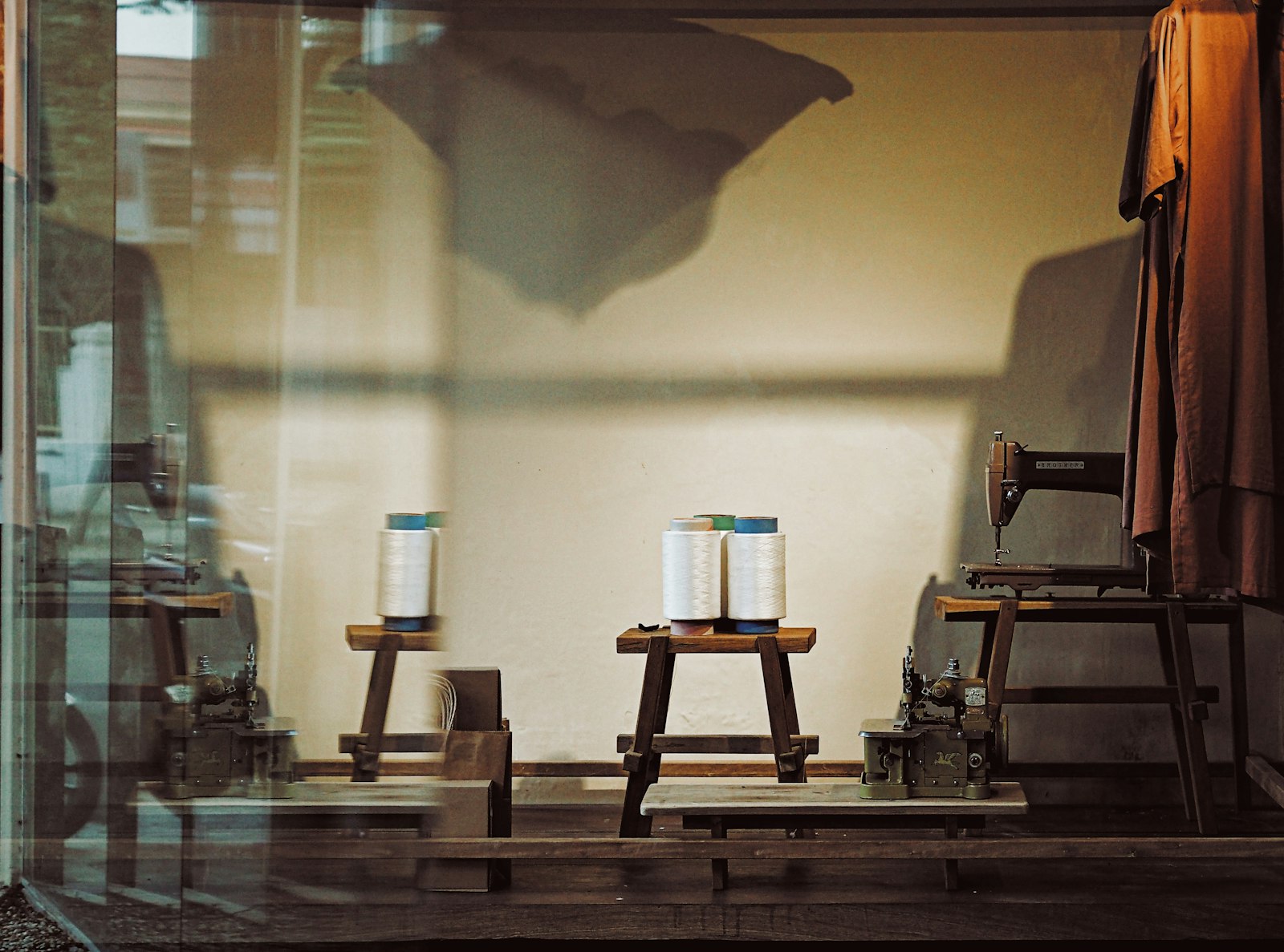 Anciennes machines à coudre et bobines de fil dans un atelier.